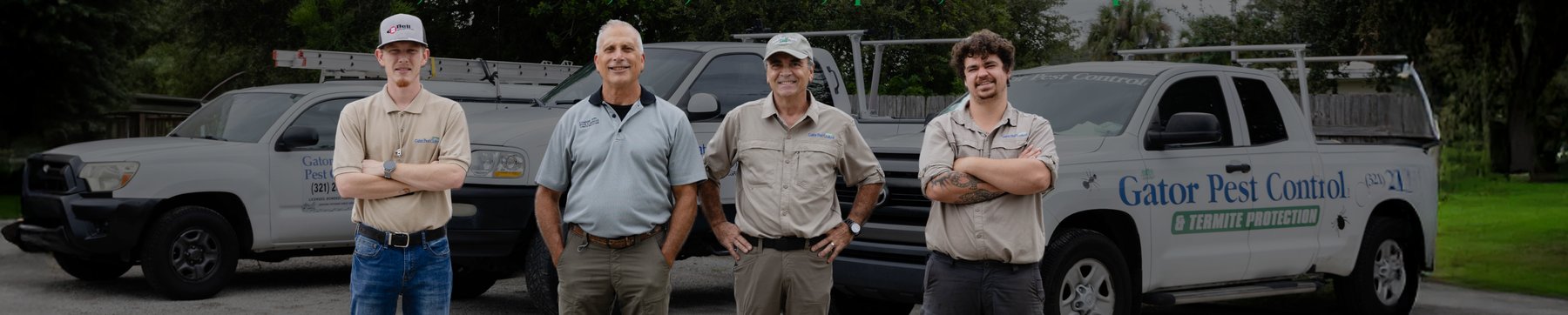 The Gator Pest Control team standing in front of their service trucks