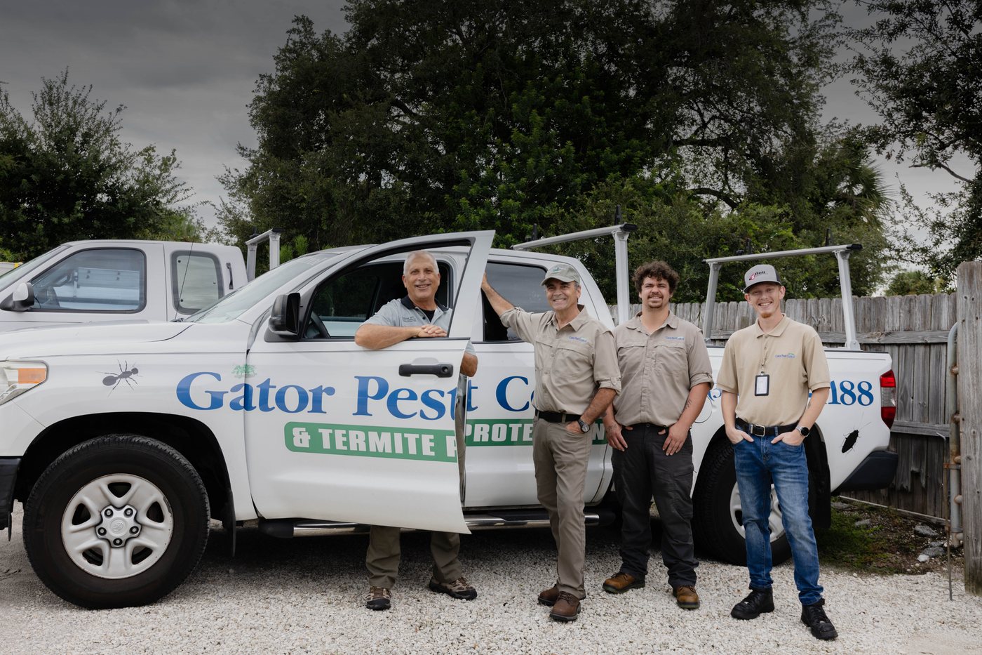 The Gator Pest Control team standing beside their termite protection trucks